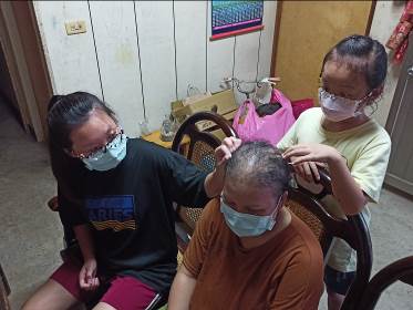 阿英(中)兩女兒心疼媽媽化療後掉髮。楊光翔攝 阿英(中)兩女兒心疼媽媽化療後掉髮。楊光翔攝