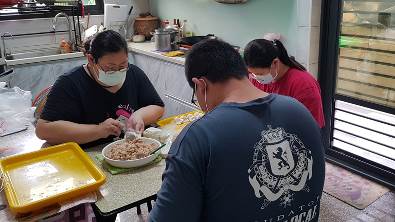 阿容(左)和一對子女包水餃賣給親朋好友。韓旭爾攝 阿容(左)和一對子女包水餃賣給親朋好友。韓旭爾攝