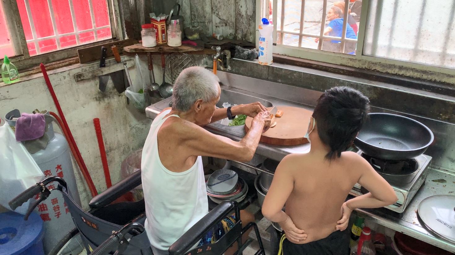 阿祥化療體弱時,7旬老父則坐著輪椅料理晚餐,右為讀小二的外甥。張嘉恬攝 阿祥化療體弱時,7旬老父則坐著輪椅料理晚餐,右為讀小二的外甥。張嘉恬攝