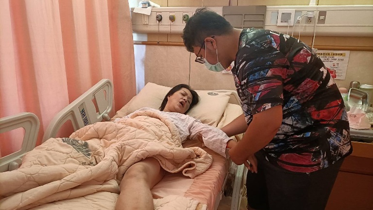 剛上大一的小譽(右)因雙親接連病倒,他休學照顧父母,圖為他在病房幫母林玉芬做復健。(圖:親友提供) 剛上大一的小譽(右)因雙親接連病倒,他休學照顧父母,圖為他在病房幫母林玉芬做復健。(圖:親友提供)