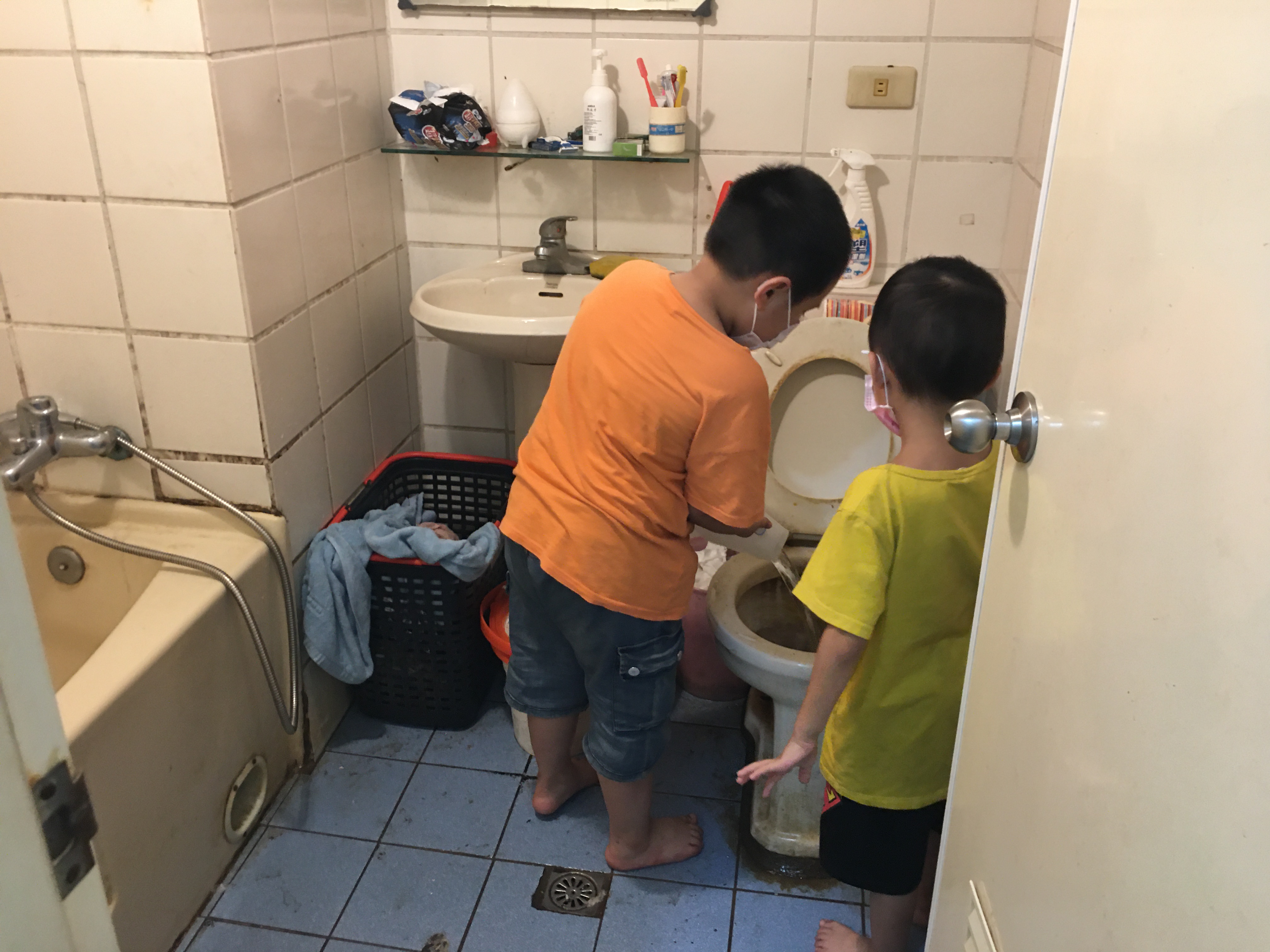 讀小二的長子小杰(左)幫忙臥床養傷的父親清洗尿桶,右為6歲次子。向高彬攝 讀小二的長子小杰(左)幫忙臥床養傷的父親清洗尿桶,右為6歲次子。向高彬攝