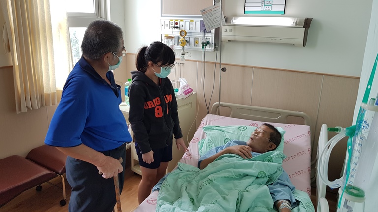 單親爸阿雄(右)生前住院治療時,他身障哥哥阿成(左)帶著阿雄讀小五的女兒小欣前往探病。韓旭爾攝 單親爸阿雄(右)生前住院治療時,他身障哥哥阿成(左)帶著阿雄讀小五的女兒小欣前往探病。韓旭爾攝