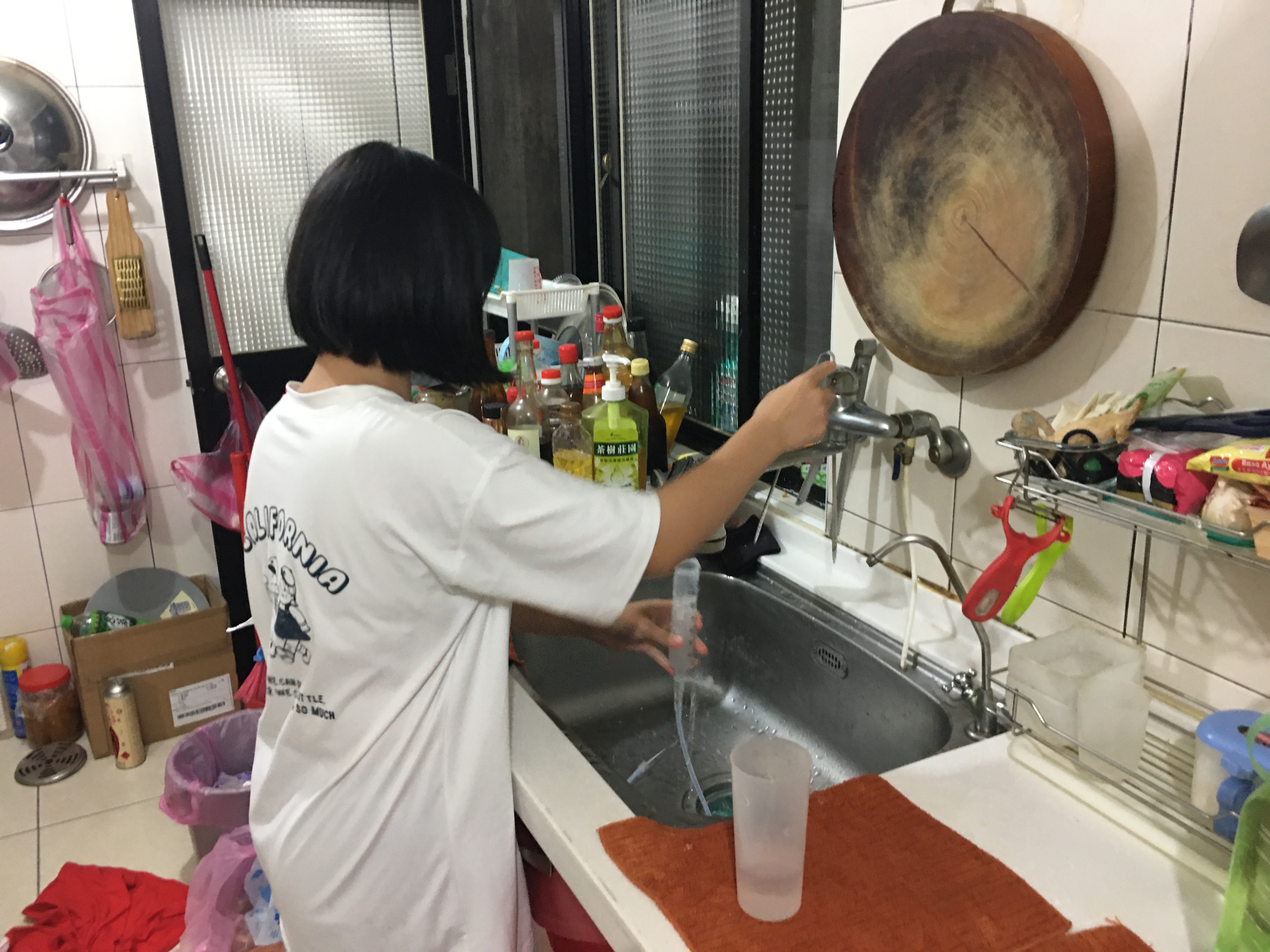 讀國二的小芃協助母親顧癌父,清洗管灌器具。向高彬攝 讀國二的小芃協助母親顧癌父,清洗管灌器具。向高彬攝