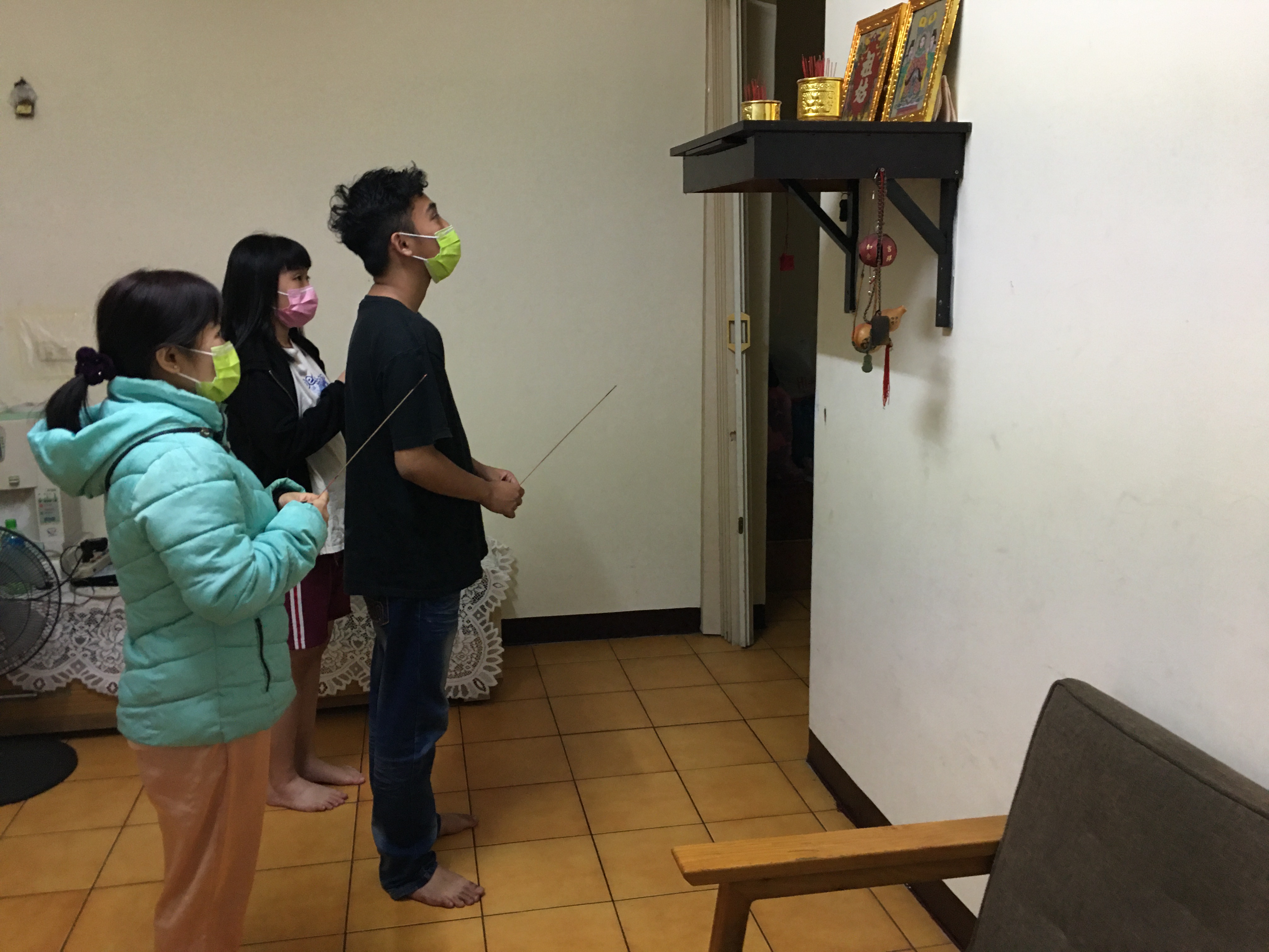 吳美琳(左)與兩子女祈求家中神明,保佑先生快康復。向高彬攝 吳美琳(左)與兩子女祈求家中神明,保佑先生快康復。向高彬攝