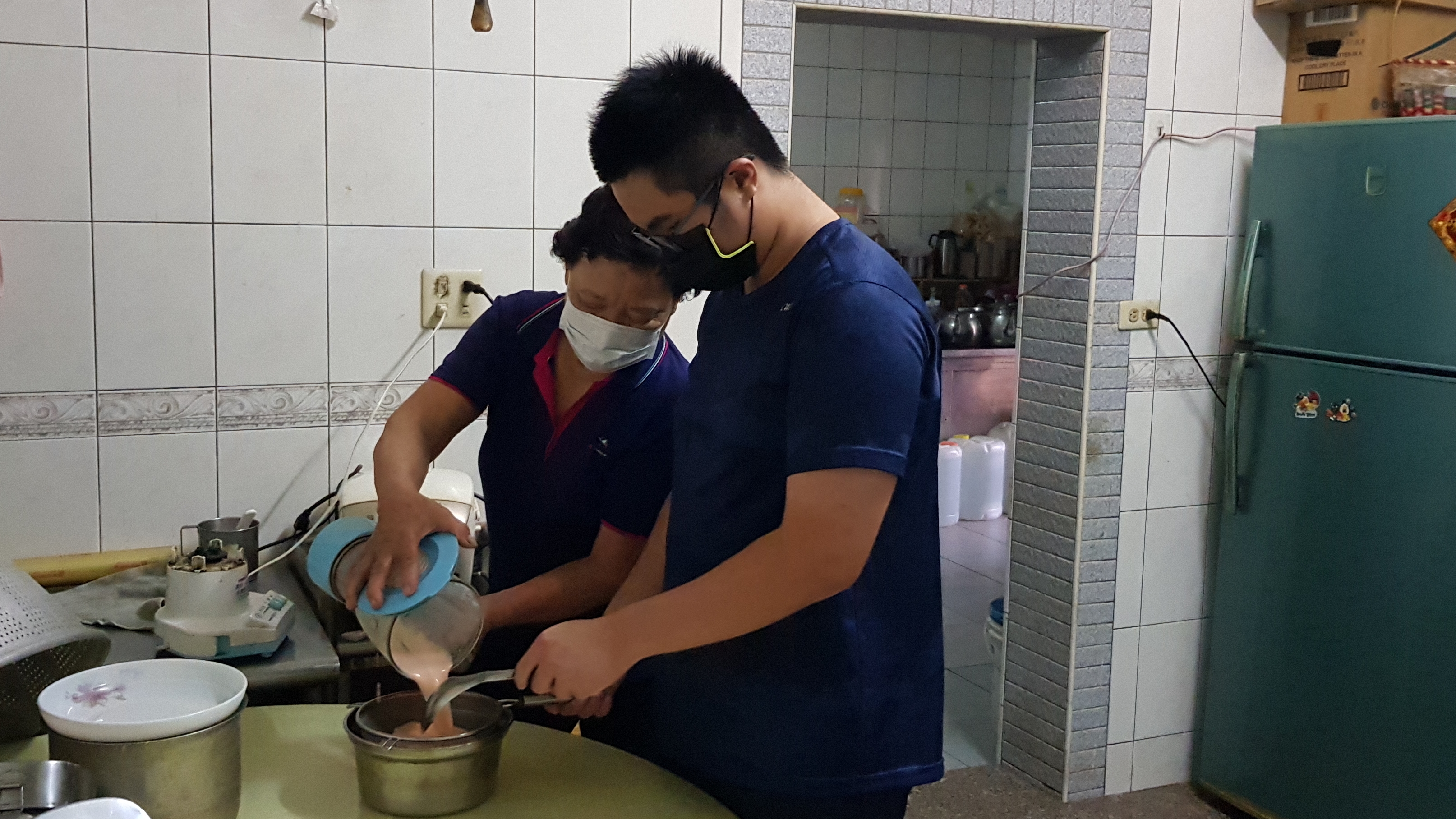 阿美婆(後)和讀國三孫子小明幫兒子打流質食物。韓旭爾攝 阿美婆(後)和讀國三孫子小明幫兒子打流質食物。韓旭爾攝