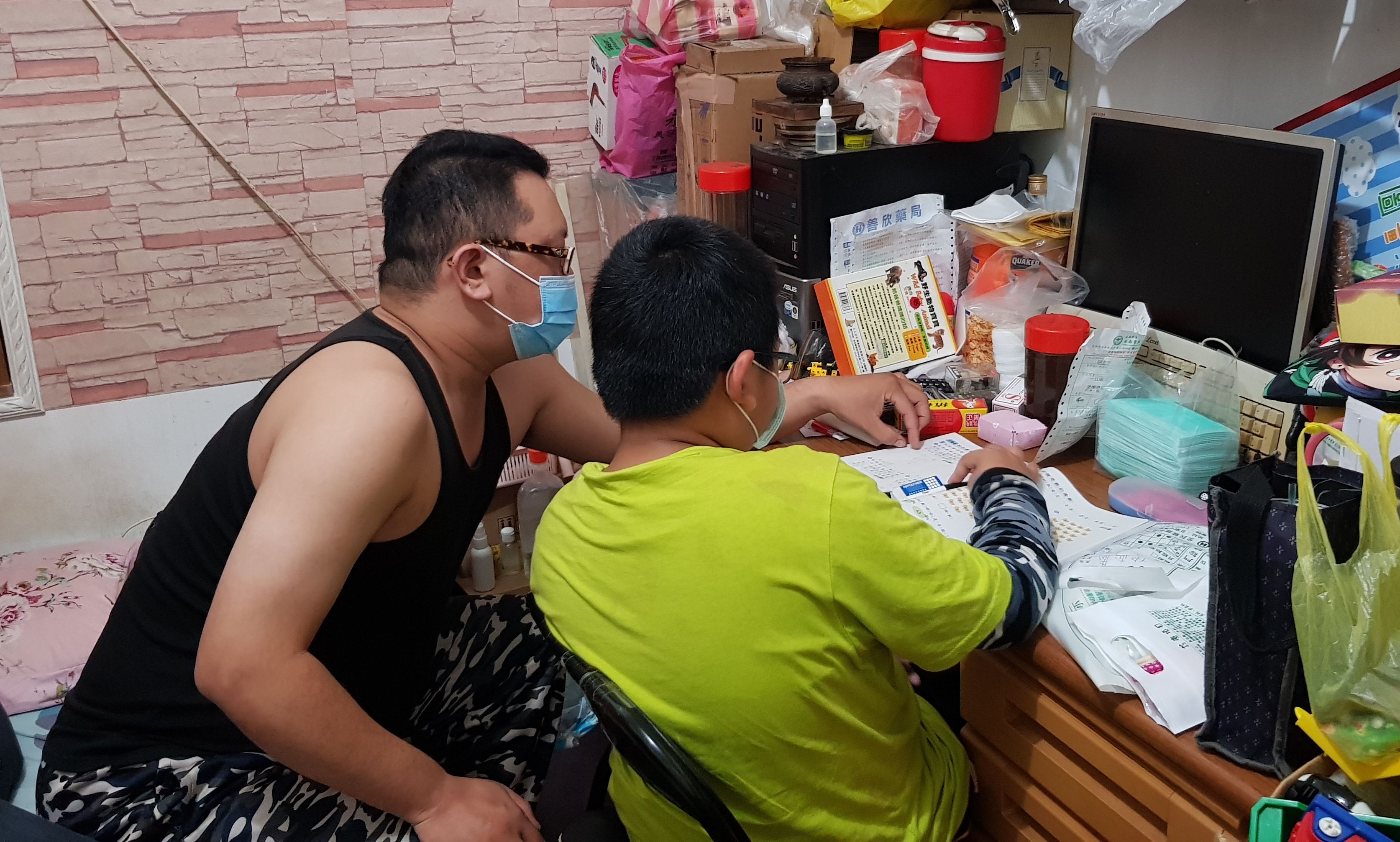 罹患黑色素瘤單親爸阿忠(左)教讀小三的獨生子小威功課。韓旭爾攝 罹患黑色素瘤單親爸阿忠(左)教讀小三的獨生子小威功課。韓旭爾攝