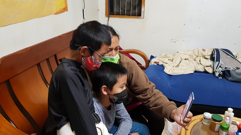 阿玲(後)和2個兒子小輝(前)、小宏(中)與罹肝硬化住院的先生阿棟視訊,2個孩子幫爸爸加油打氣。韓旭爾攝 阿玲(後)和2個兒子小輝(前)、小宏(中)與罹肝硬化住院的先生阿棟視訊,2個孩子幫爸爸加油打氣。韓旭爾攝