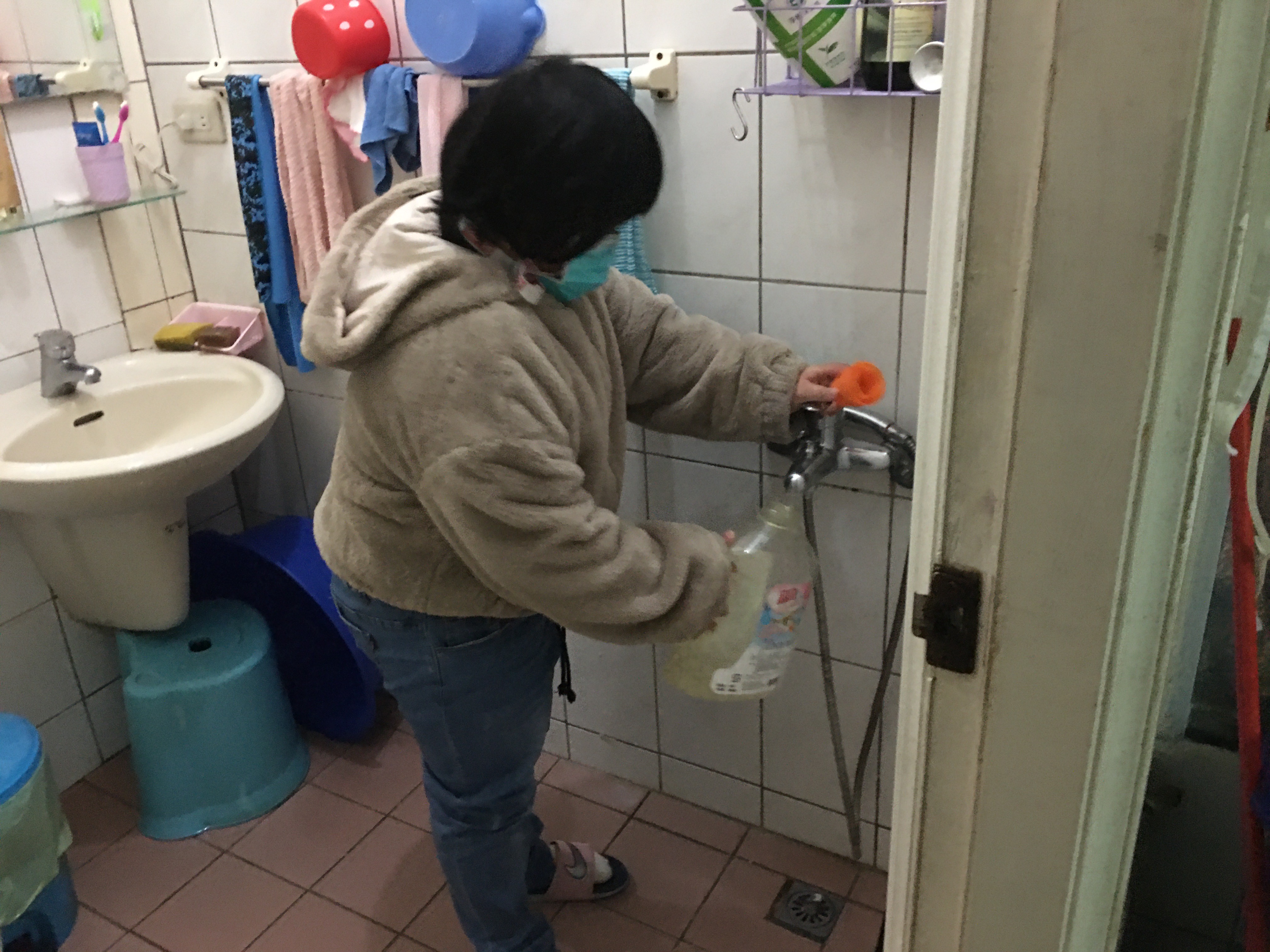 小恩幫提哥哥阿俊的尿桶到廁所清洗。向高彬攝 小恩幫提哥哥阿俊的尿桶到廁所清洗。向高彬攝