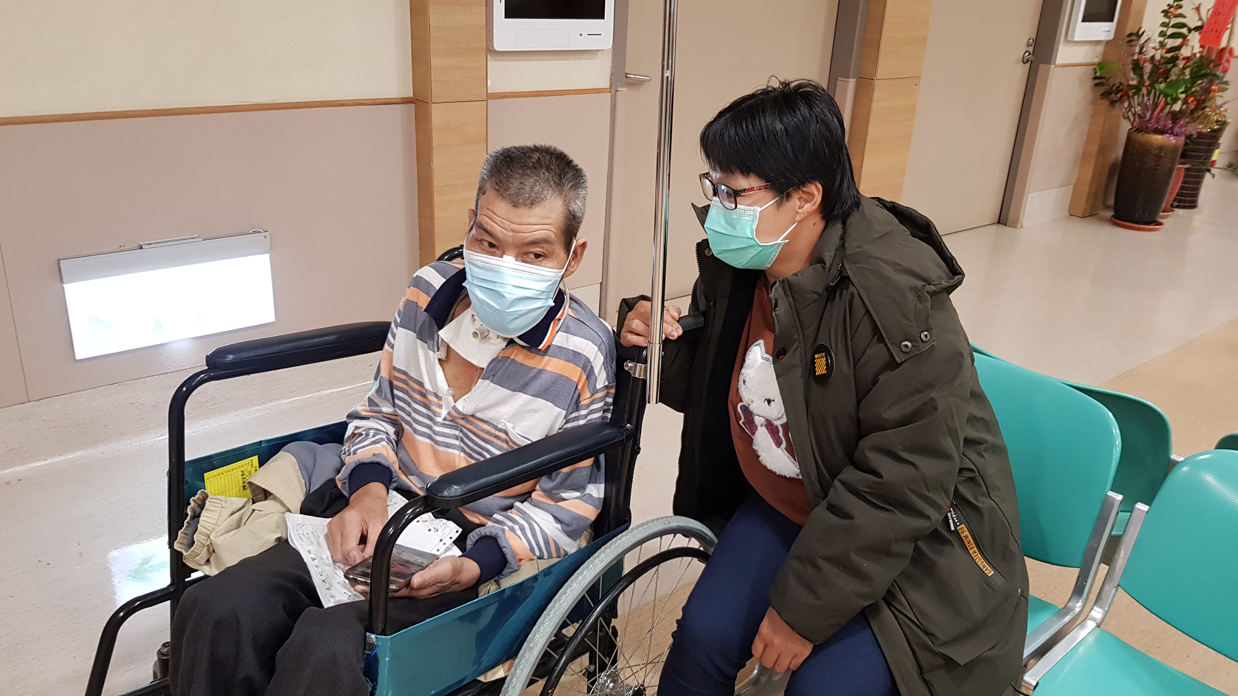 阿玲(右)用輪椅推先生阿雄回診。韓旭爾攝 阿玲(右)用輪椅推先生阿雄回診。韓旭爾攝