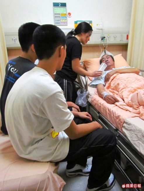 8年前,勝彥父親(躺病床者)罹癌又中風倒下,當時就讀國中的勝彥與弟弟(左前)及母親(中)在醫院照料。資料照 8年前,勝彥父親(躺病床者)罹癌又中風倒下,當時就讀國中的勝彥與弟弟(左前)及母親(中)在醫院照料。資料照