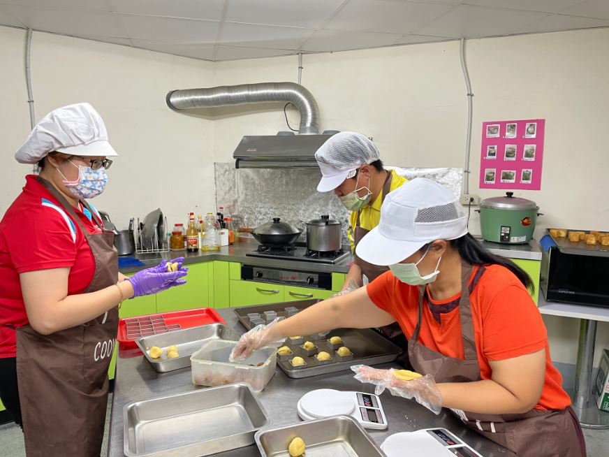 屏東縣向陽啟能協會學員在老師(左)指導下製作鳳梨酥。李佳玲攝 屏東縣向陽啟能協會學員在老師(左)指導下製作鳳梨酥。李佳玲攝