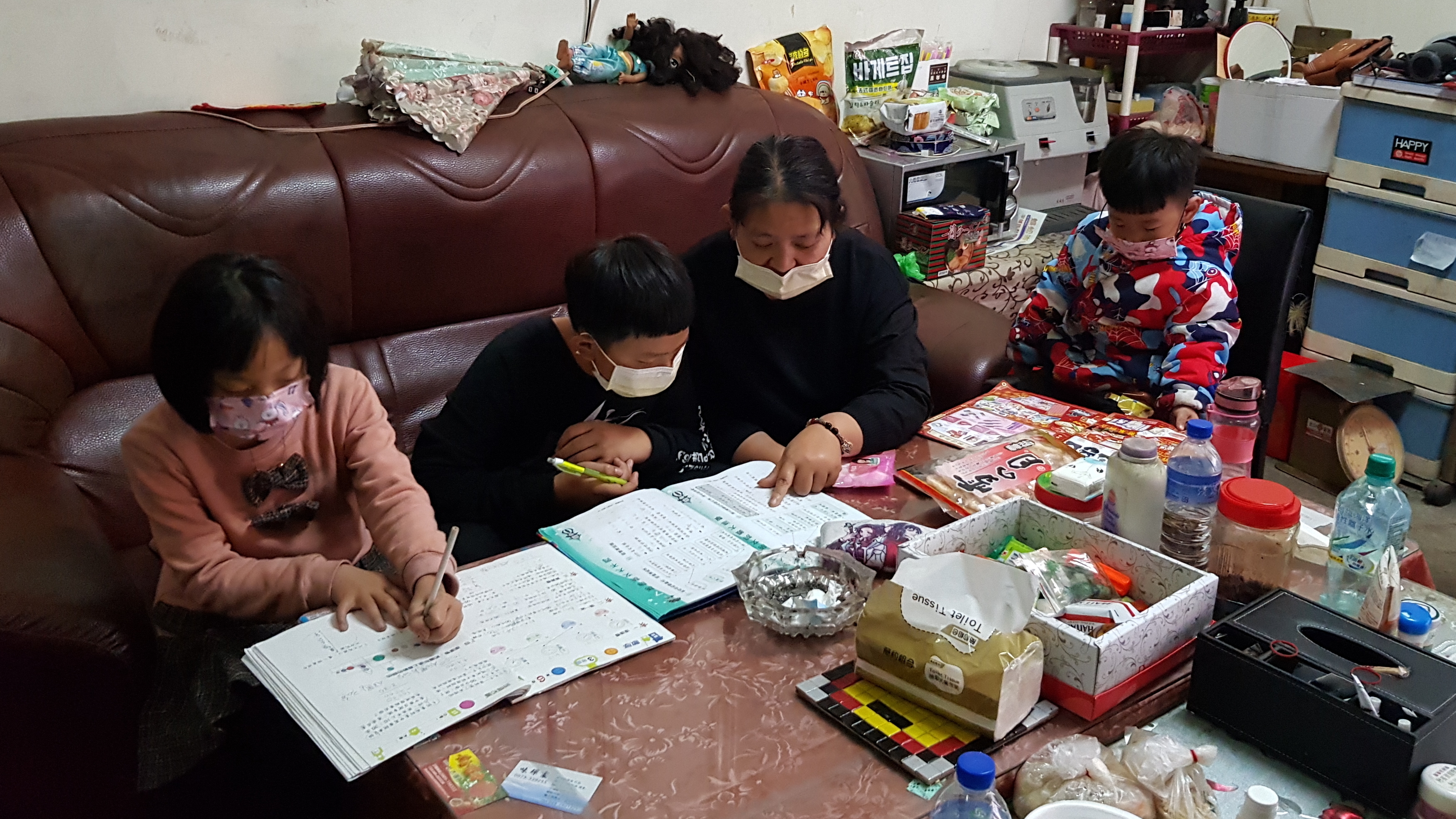 阿君(右2)教導讀國小的2子女寫功課,右1為4歲孫子小冠。韓旭爾攝 阿君(右2)教導讀國小的2子女寫功課,右1為4歲孫子小冠。韓旭爾攝