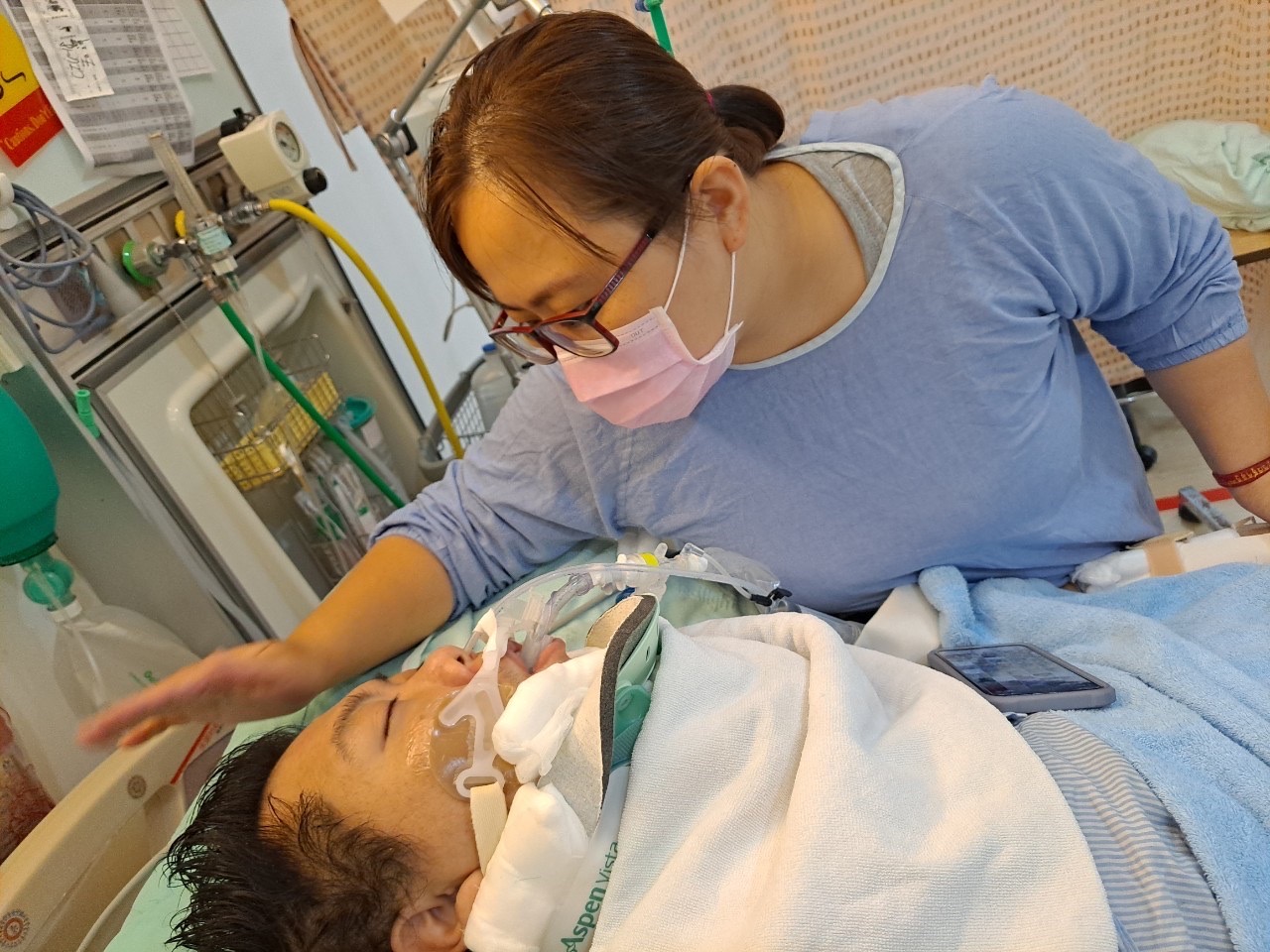 林雅芳(右)在加護病房探望病癱夫。(圖:親友提供) 林雅芳(右)在加護病房探望病癱夫。(圖:親友提供)
