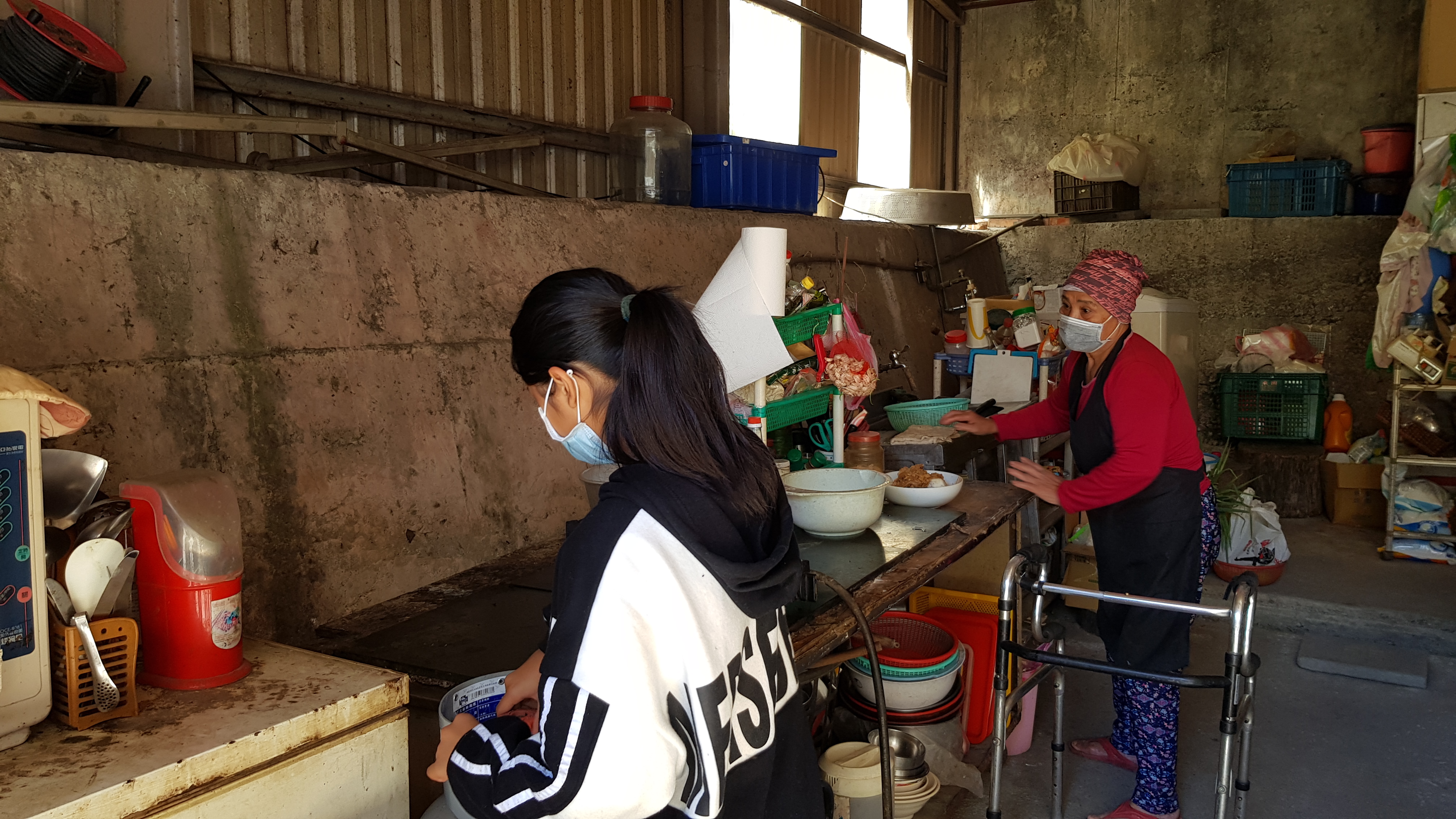 阿貞婆(後)行動不便,她正扶著助行器料理午餐,孫女小汶在旁幫忙。韓旭爾攝 阿貞婆(後)行動不便,她正扶著助行器料理午餐,孫女小汶在旁幫忙。韓旭爾攝