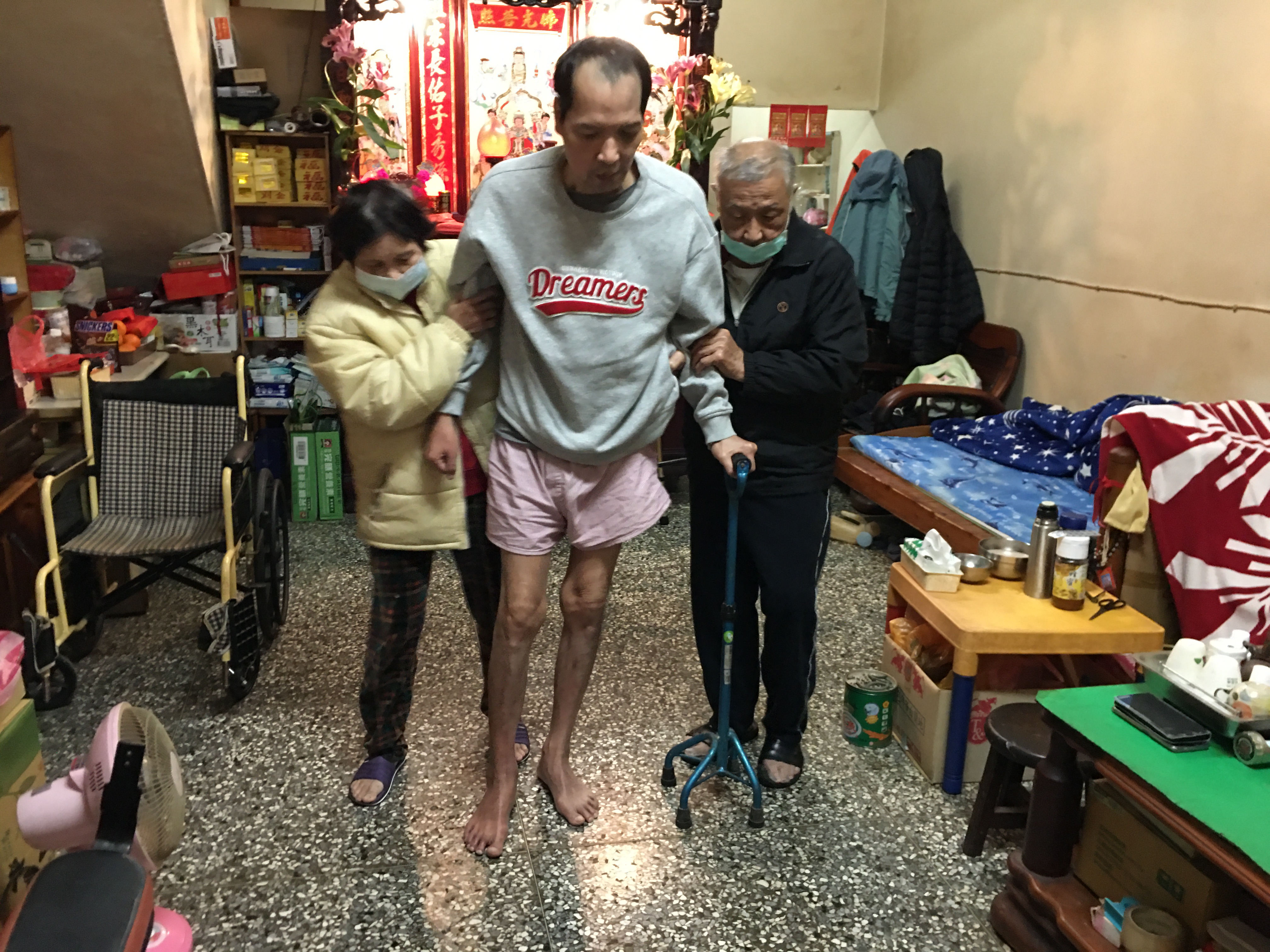 吳訓雄(右)與老伴林細油(左)撐扶中風長子阿柏復健練走。向高彬攝 吳訓雄(右)與老伴林細油(左)撐扶中風長子阿柏復健練走。向高彬攝