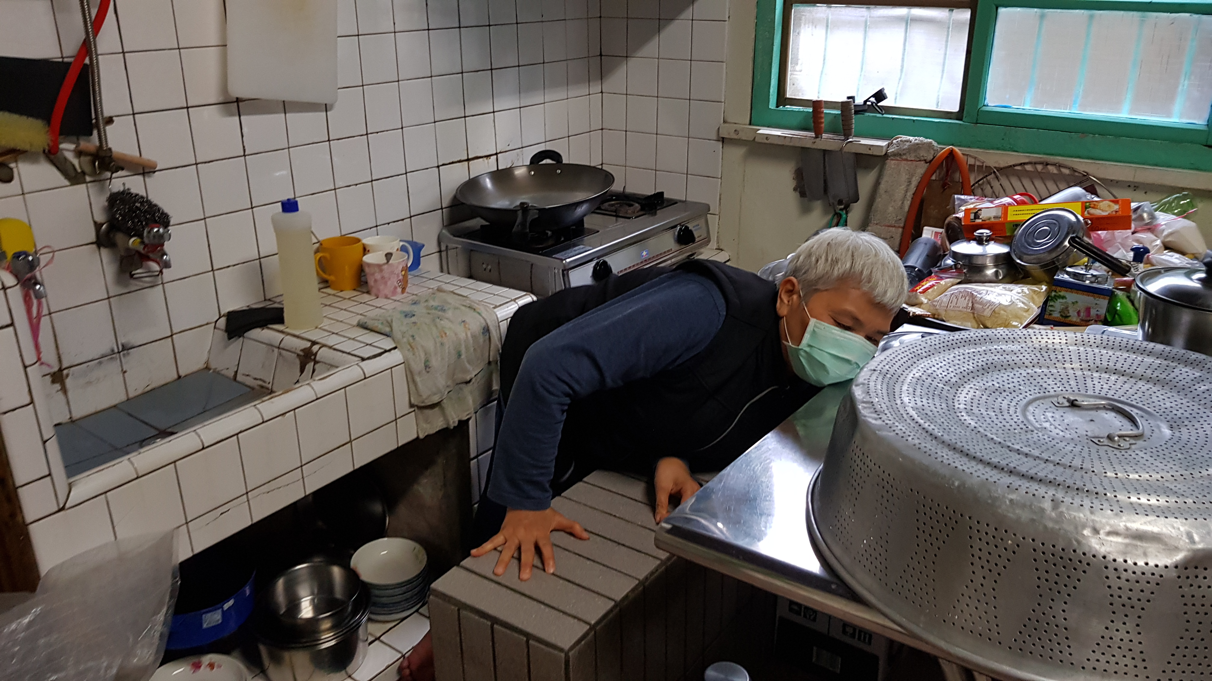 行動不便的阿香婆爬上水泥長椅準備料理午餐。韓旭爾攝 行動不便的阿香婆爬上水泥長椅準備料理午餐。韓旭爾攝