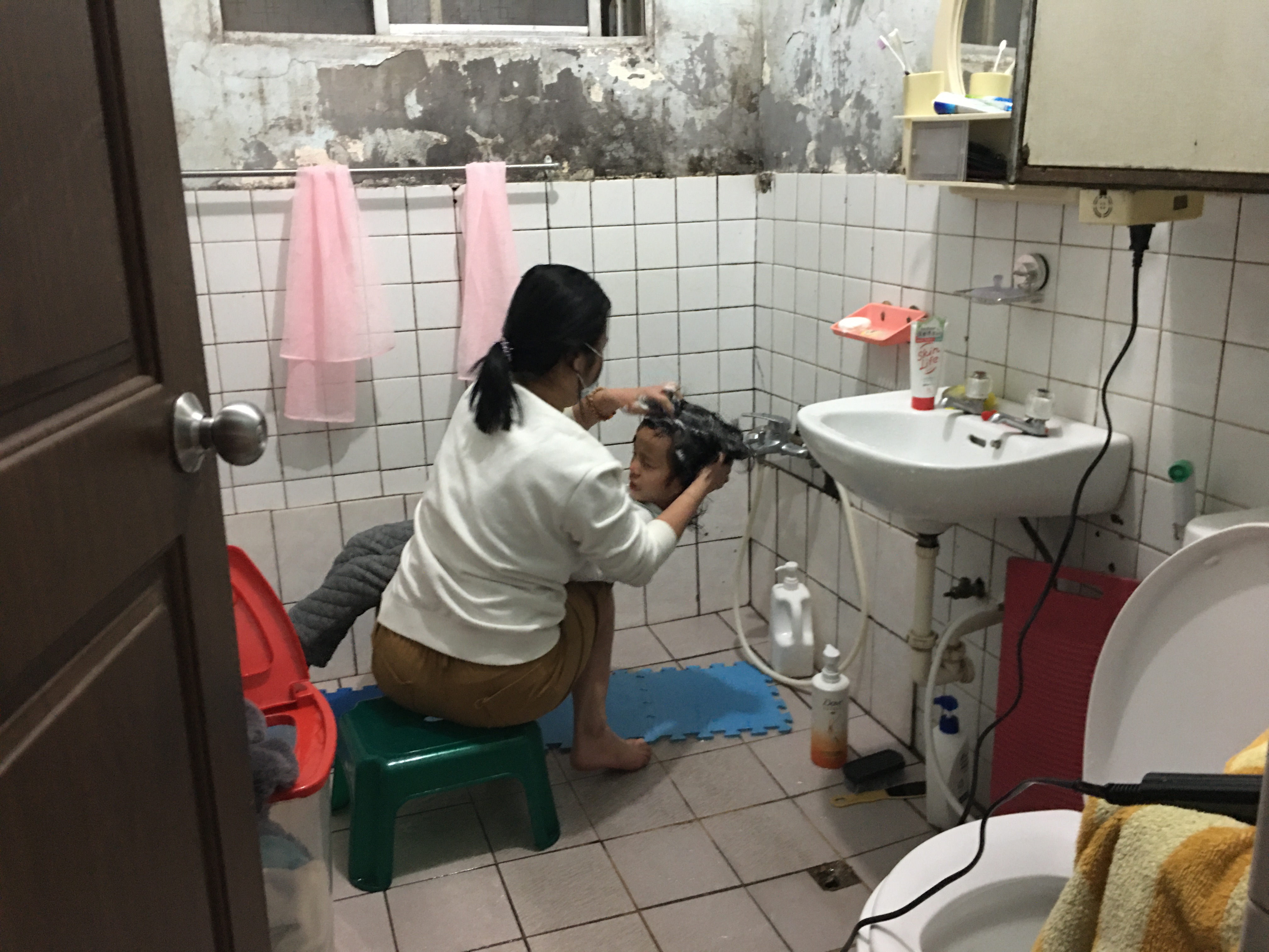 王佳雅(左)幫么女洗頭,她說,孩子像個需人照顧的大娃娃。向高彬攝 王佳雅(左)幫么女洗頭,她說,孩子像個需人照顧的大娃娃。向高彬攝
