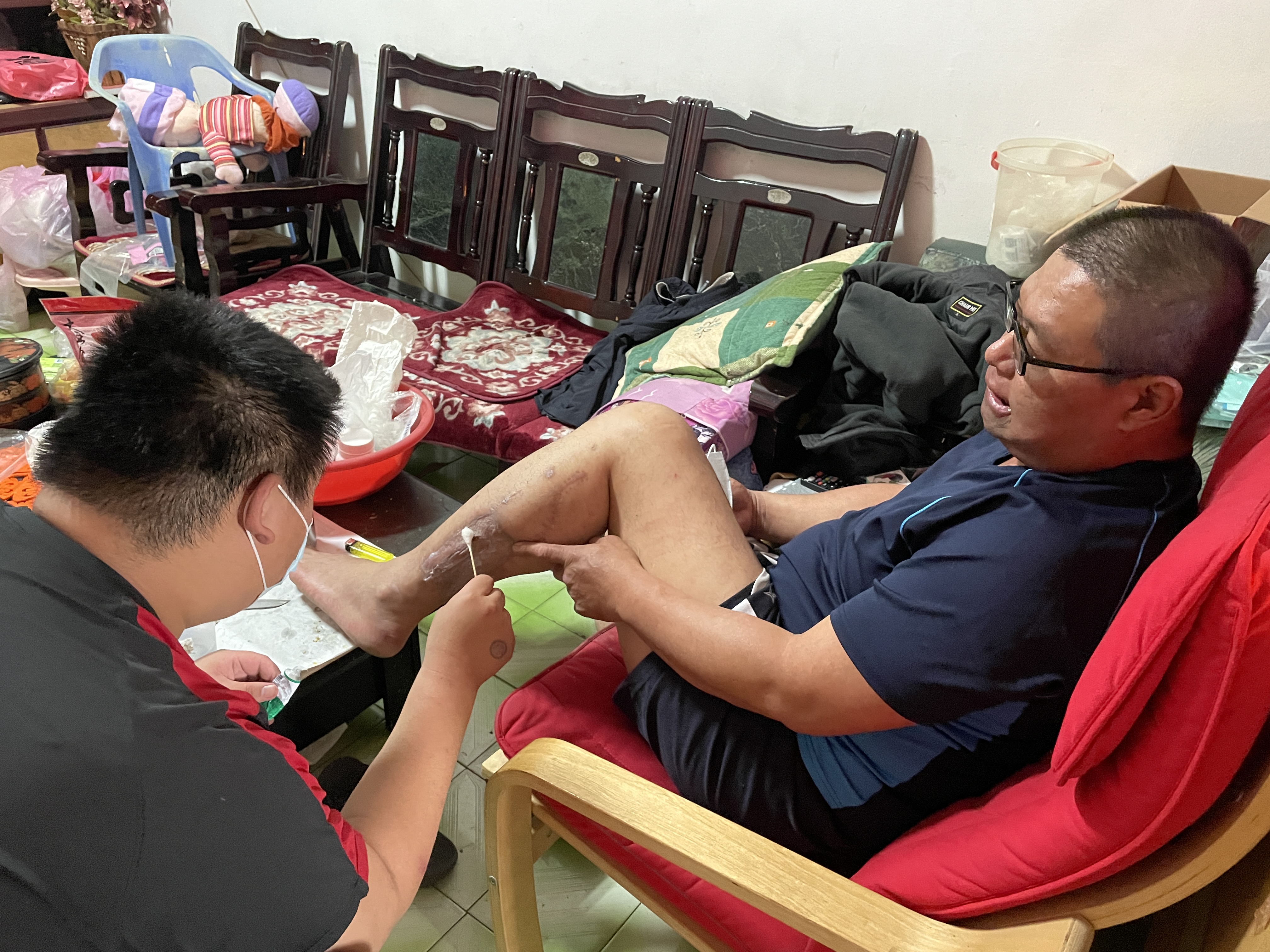 葉集亮兒子(左)利用課餘時間前往關心爸爸情況,並協助擦藥。李佳玲攝 葉集亮兒子(左)利用課餘時間前往關心爸爸情況,並協助擦藥。李佳玲攝