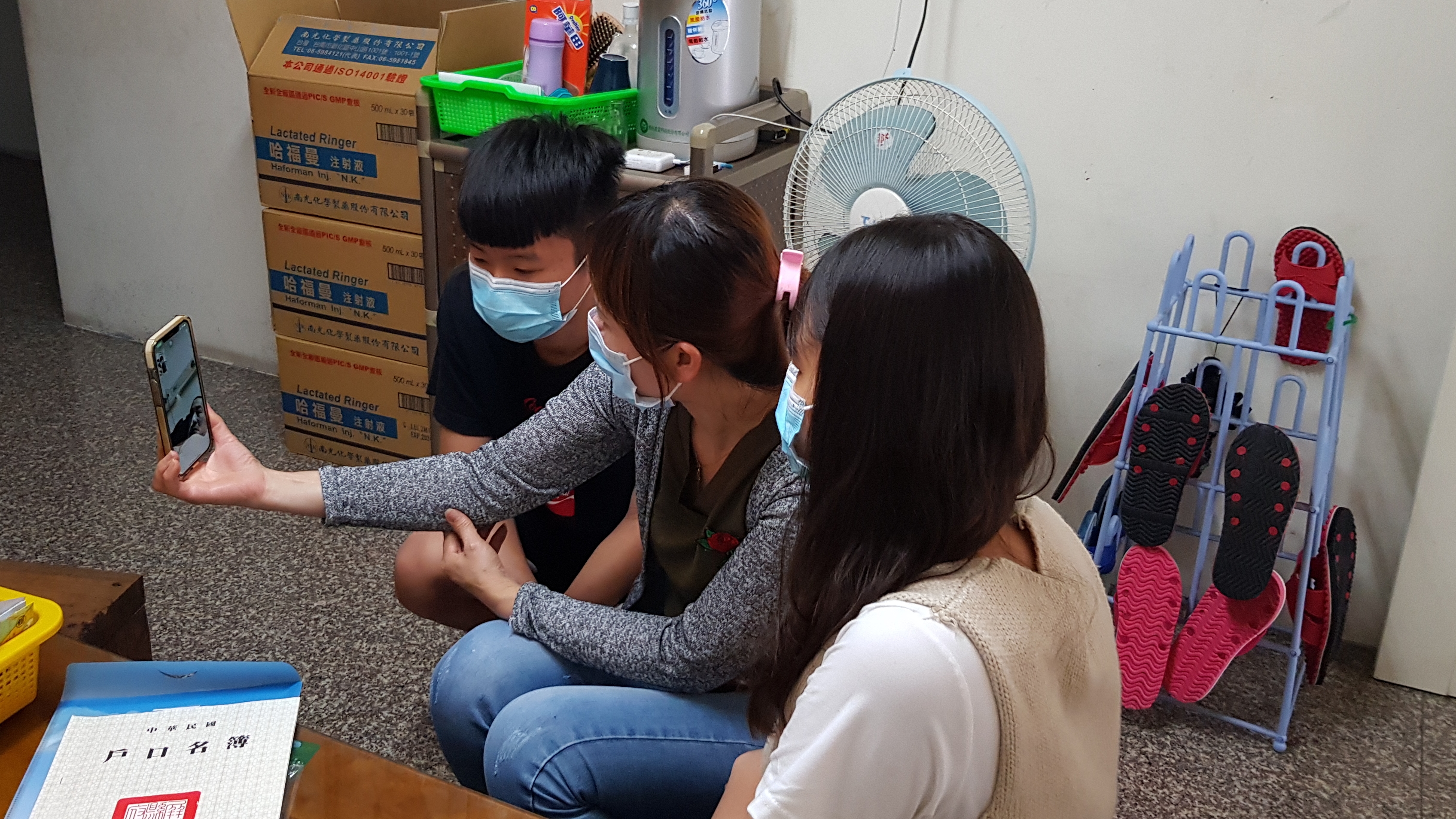 阿貞(中)返家和2子女小屏(右)、小凱跟住院的先生阿富視訊。韓旭爾攝 阿貞(中)返家和2子女小屏(右)、小凱跟住院的先生阿富視訊。韓旭爾攝