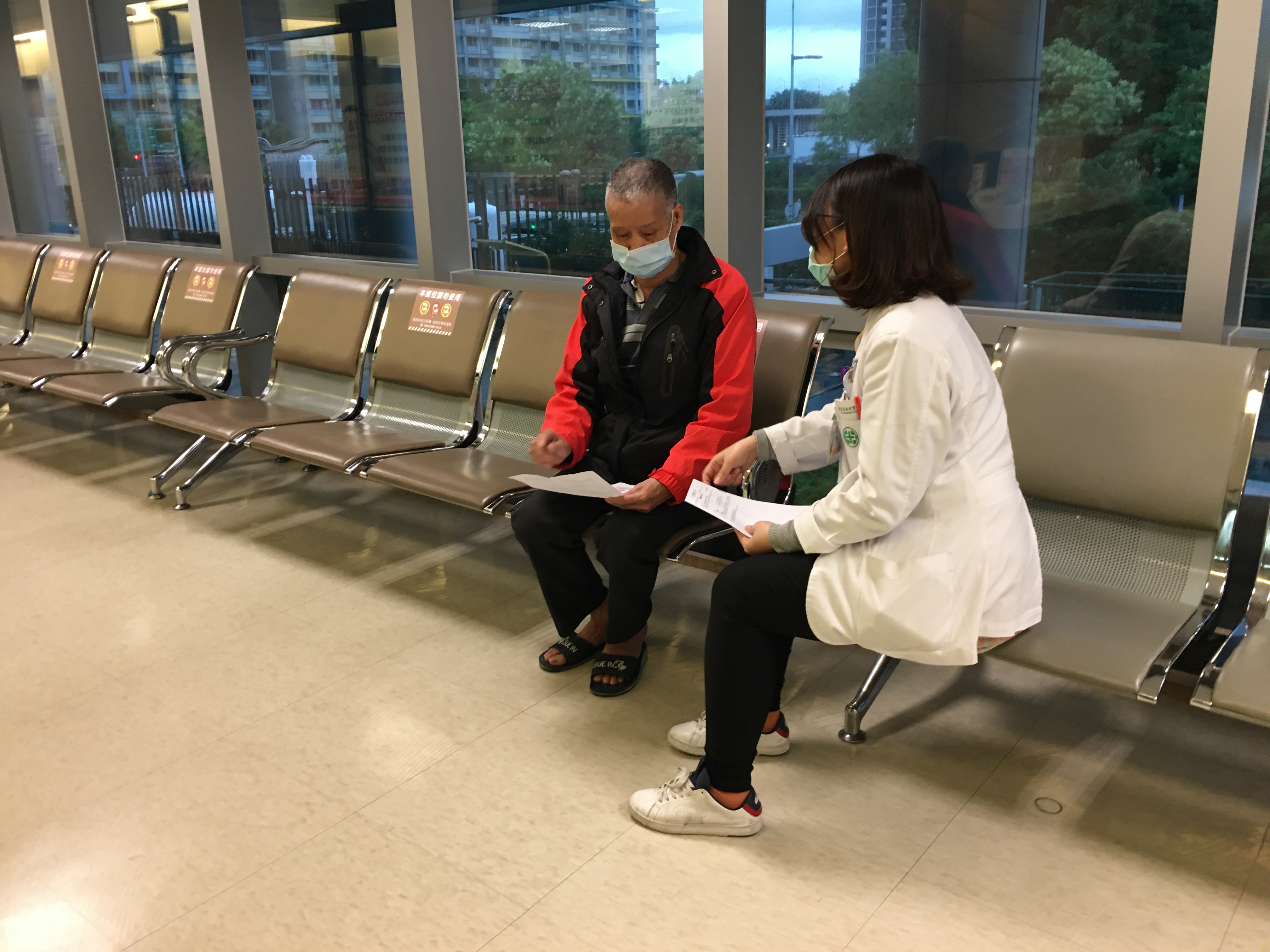 吳輝西(左)在醫院回診,醫院社工與他鼓勵抗癌。向高彬攝 吳輝西(左)在醫院回診,醫院社工與他鼓勵抗癌。向高彬攝