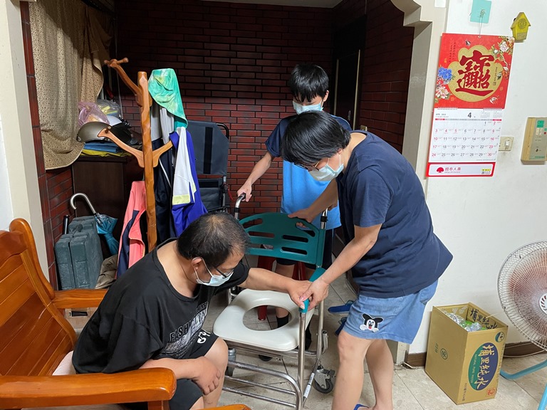 楊東財(左)現無力站起,仍需國3繼子(中)及妻子鄭淑眞(右)協助照顧。李佳玲攝 楊東財(左)現無力站起,仍需國3繼子(中)及妻子鄭淑眞(右)協助照顧。李佳玲攝