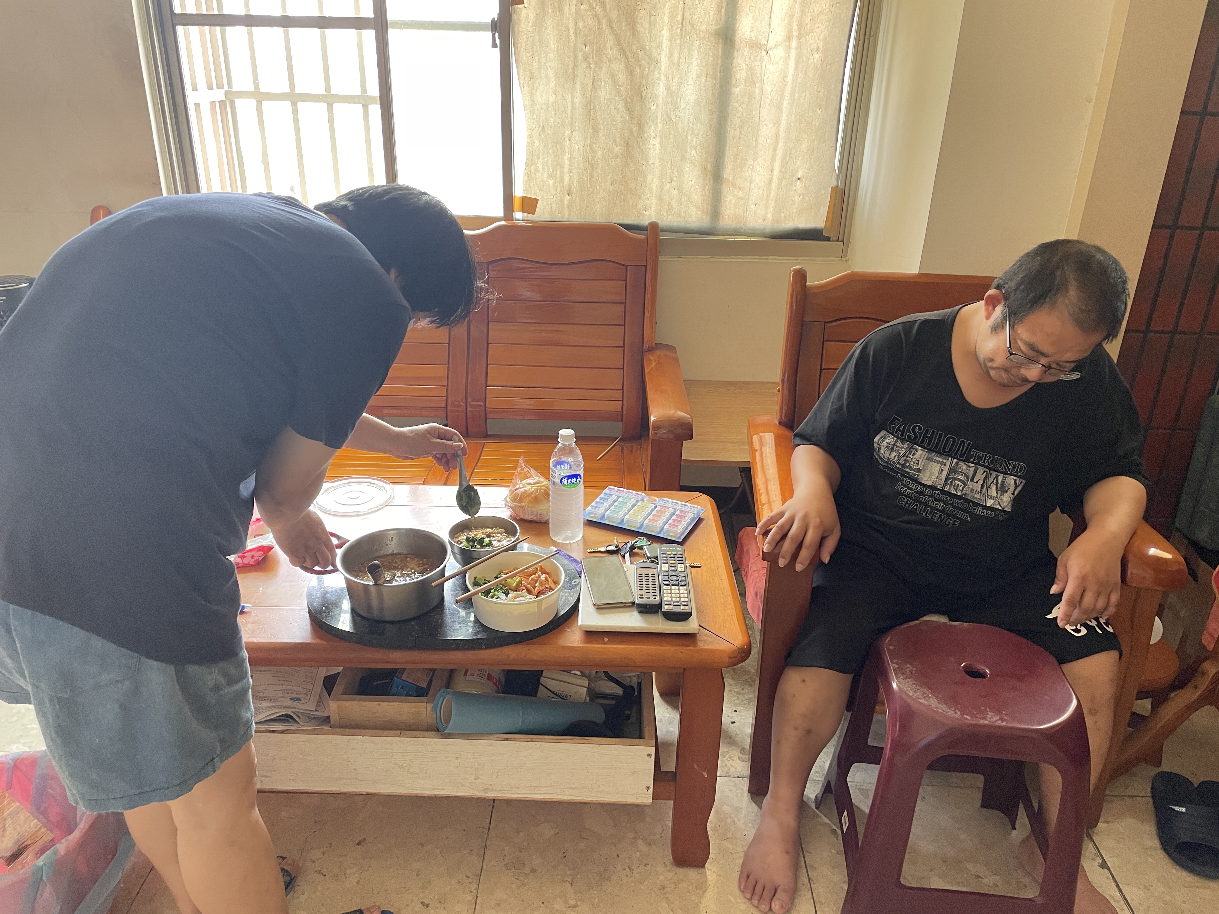 鄭淑眞(左)趁工作午休返家照料中風中風先生楊東財(右)。李佳玲攝 鄭淑眞(左)趁工作午休返家照料中風中風先生楊東財(右)。李佳玲攝