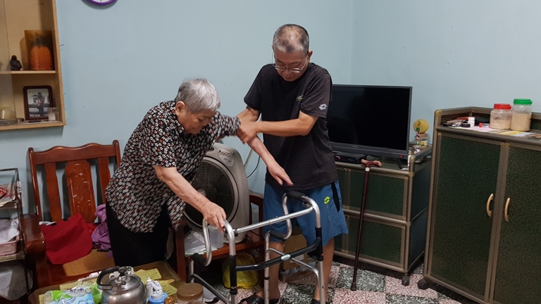 罹4期喉癌的阿宗(右)攙扶行動不便的老媽媽春妹婆。韓旭爾攝 罹4期喉癌的阿宗(右)攙扶行動不便的老媽媽春妹婆。韓旭爾攝
