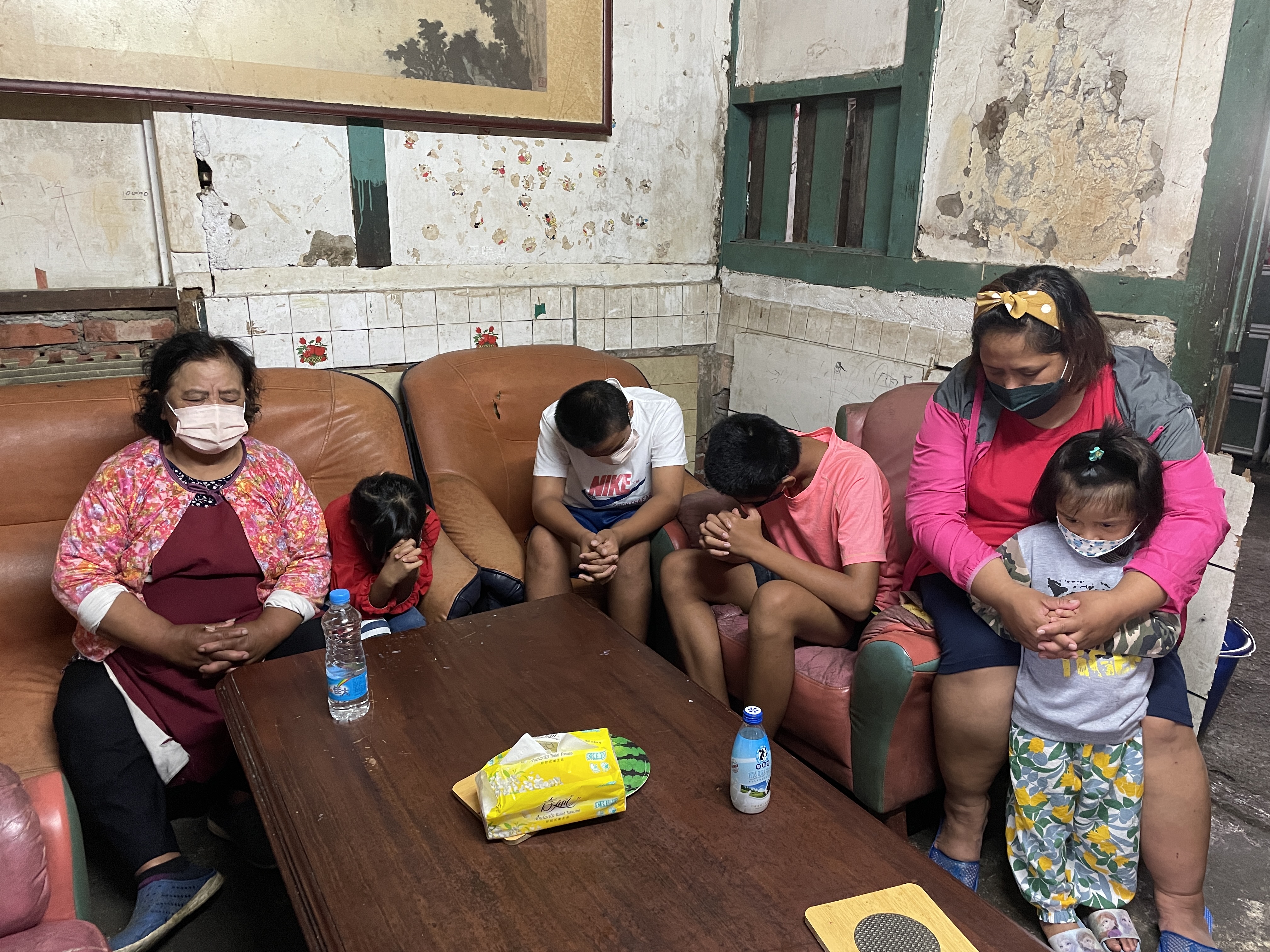 5月中記者訪視時,米亞萍(右後)和子女們及婆婆(左)一起禱告,但阿忠仍難敵病魔去世。李佳玲攝 5月中記者訪視時,米亞萍(右後)和子女們及婆婆(左)一起禱告,但阿忠仍難敵病魔去世。李佳玲攝