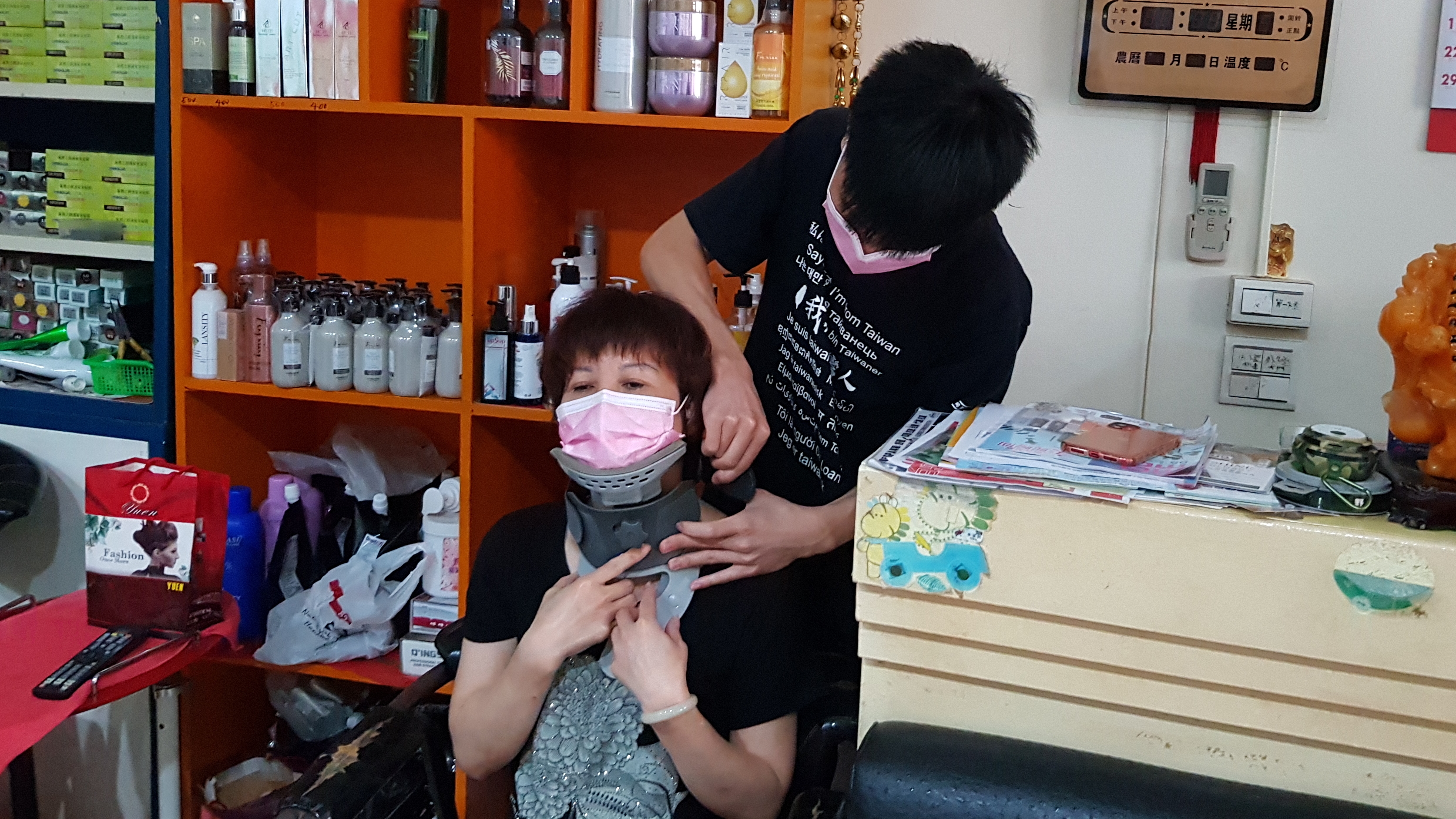小盛(右)幫脊椎滑脫壓迫神經的媽媽阿鳳戴上居家頸椎牽引器做復健。韓旭爾攝 小盛(右)幫脊椎滑脫壓迫神經的媽媽阿鳳戴上居家頸椎牽引器做復健。韓旭爾攝