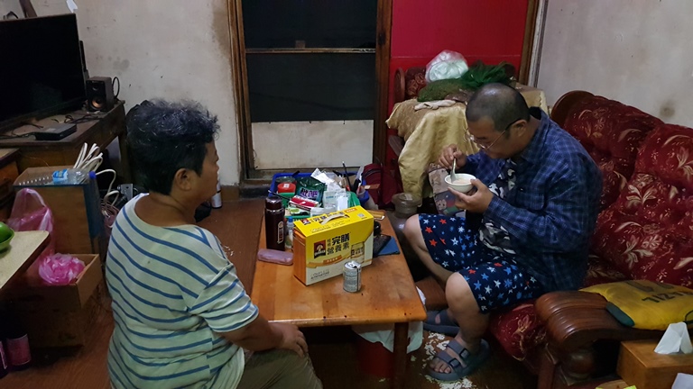初訪阿笙(右)尚未手術,罹4期舌癌的他正啜飲營養品,一旁媽媽阿蘭婆為病子憂心忡忡。韓旭爾攝 初訪阿笙(右)尚未手術,罹4期舌癌的他正啜飲營養品,一旁媽媽阿蘭婆為病子憂心忡忡。韓旭爾攝
