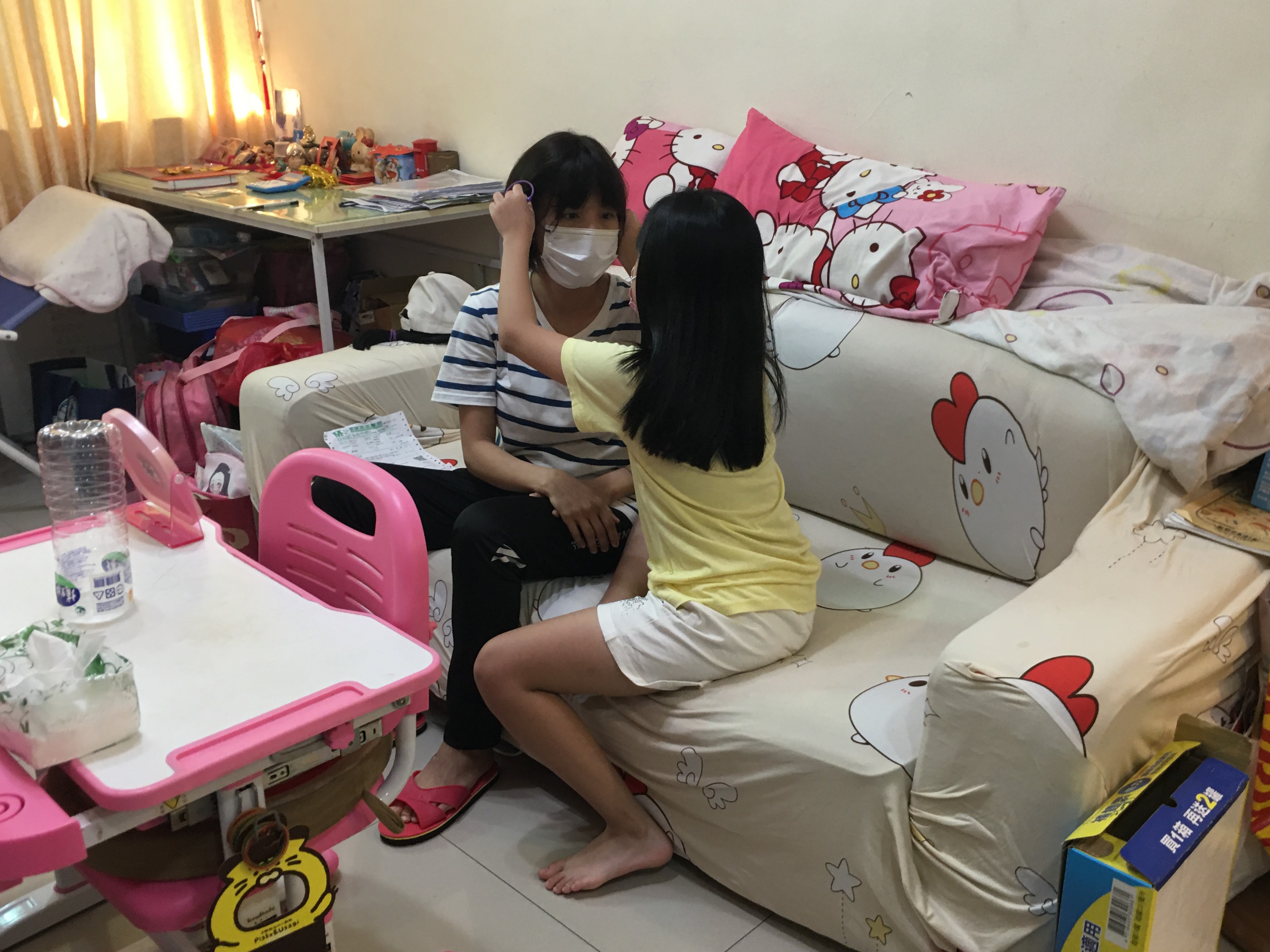 9歲女兒幫媽媽潘翠娜(左)看假髮有無戴好。向高彬攝 9歲女兒幫媽媽潘翠娜(左)看假髮有無戴好。向高彬攝